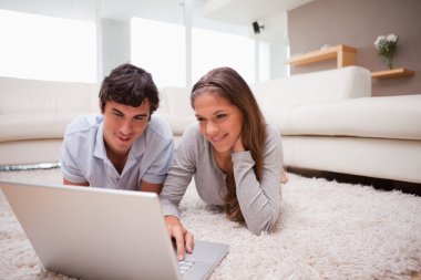 Couple with laptop on the floor clipart