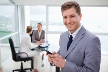 Sales manager holding cellphone clipart