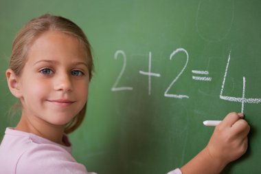 Smiling schoolgirl writing a number clipart