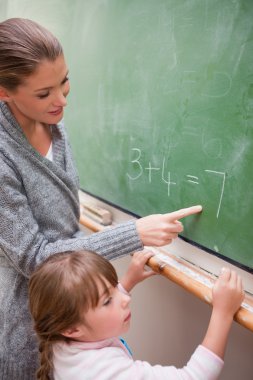 Portrait of a happy teacher and a pupil making an addition clipart