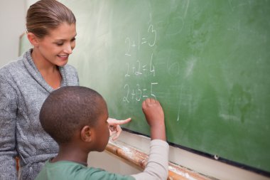 Cute teacher and a pupil making an addition clipart