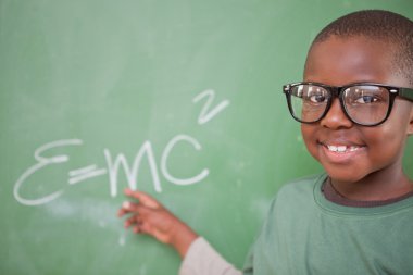 Smart schoolboy showing the mass-energy equivalence clipart
