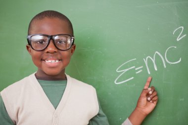 Schoolboy showing the the mass-energy equivalence formula clipart