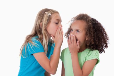 Young girl whispering a secret to her friend clipart