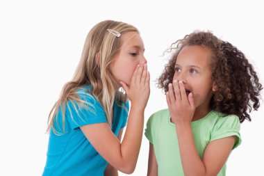 Cute girl whispering a secret to her friend clipart