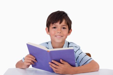 Happy boy reading a book clipart