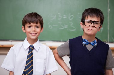 Schoolboys posing in front of a chalkboard clipart