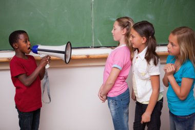 Schoolboy yelling through a megaphone to his classmates clipart