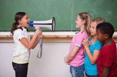 Schoolgirl yelling through a megaphone to her classmates clipart