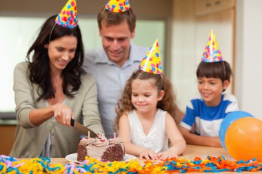 Mother cutting birthday cake clipart