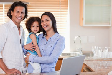 Family surfing the web in the kitchen together clipart