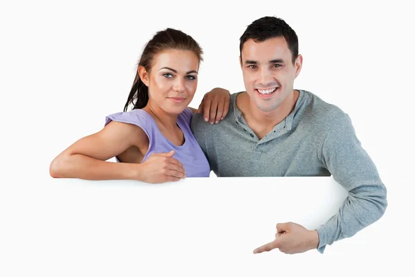 Молодая пара представляет рекламу — стоковое фото