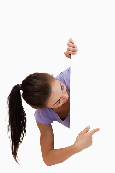 Young female pointing around the corner — Stock Photo, Image