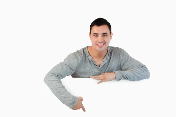 Young male pointing at banner below him — Stock Photo, Image