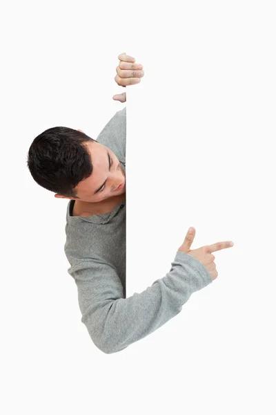 Young male pointing around the corner — Stock Photo, Image