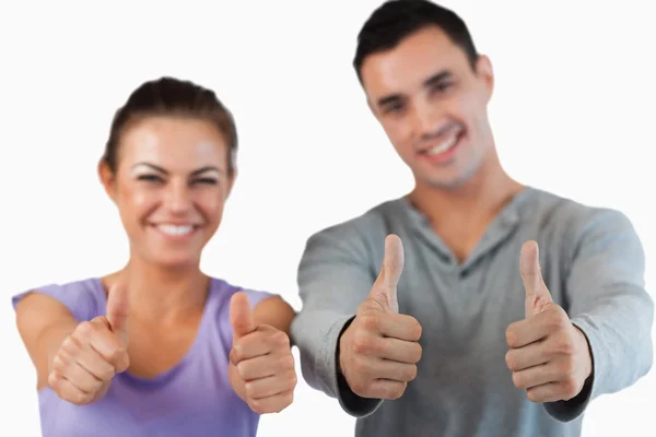 Thumbs up being given by young couple — Stock Photo, Image