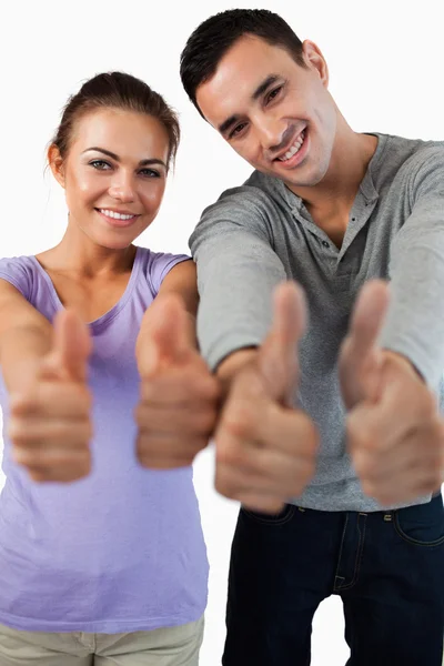 Close up de jovem casal dando polegares para cima — Fotografia de Stock