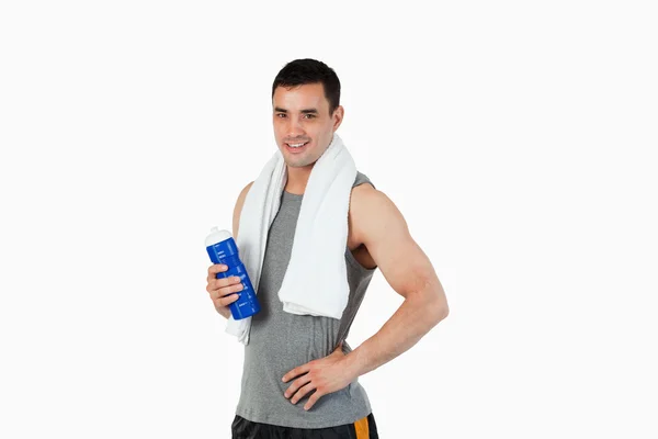 Молодой мужчина с бутылкой после тренировки — стоковое фото