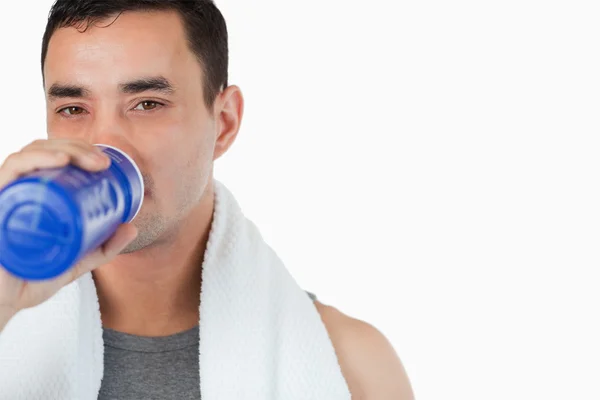 Jovem do sexo masculino tomando um gole de água após o treinamento — Fotografia de Stock