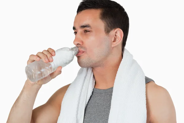 Ung man med en klunk vatten efter träning — Stockfoto