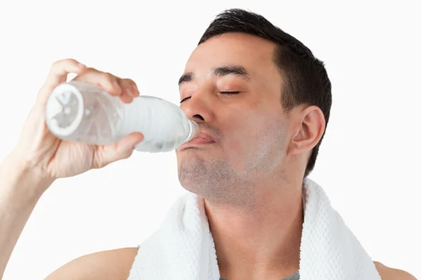 Ung man njuter en klunk vatten efter träning — Stockfoto