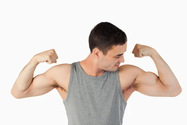 Młody człowiek, patrząc na jego mięśnie — Zdjęcie stockowe