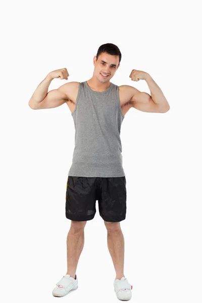 Jovem do sexo masculino apresentando seus músculos — Fotografia de Stock