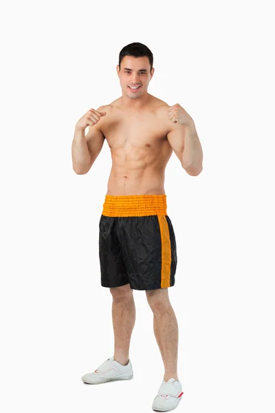 Joven boxeador sonriente con los puños desnudos arriba — Foto de Stock