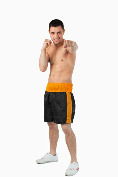 Boxeador joven con puños desnudos golpeando recto — Foto de Stock