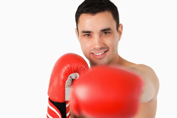 Boxeador sonriente golpeando con el puño izquierdo — Foto de Stock