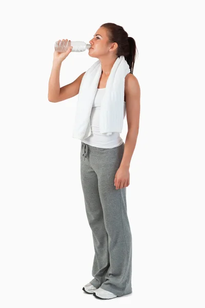 Sidovy av ung kvinna tar en klunk vatten efter träning — Stockfoto