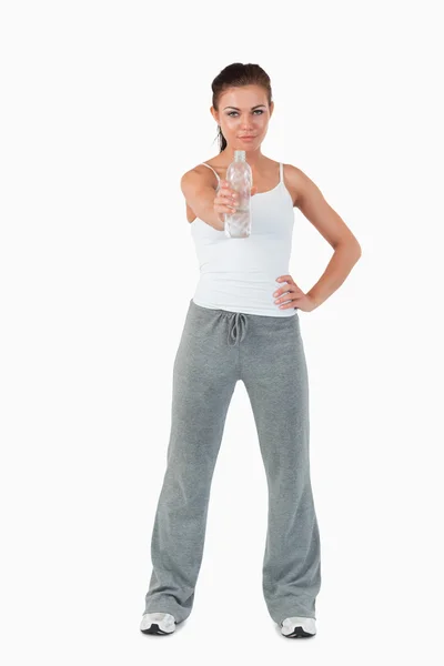 Young woman with hand on her hip offering a sip of water — Stock Photo, Image