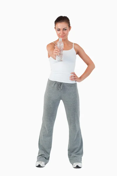 Young female with hand on her hip offering a sip of water — Stock Photo, Image