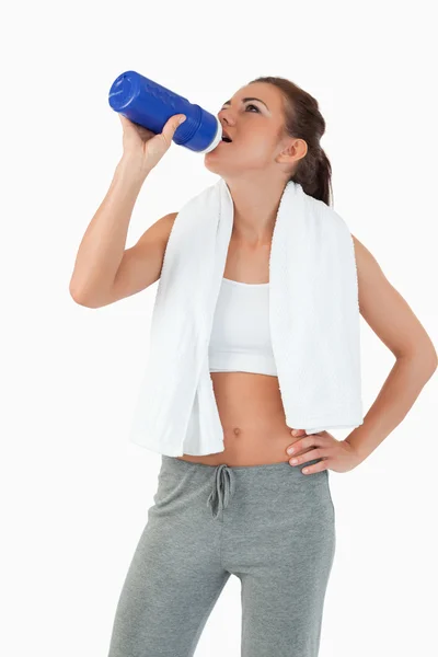 Jonge vrouw nemen een slok uit haar fles na training — Stockfoto