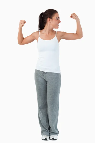 Jovem mulher olhando para o bíceps — Fotografia de Stock