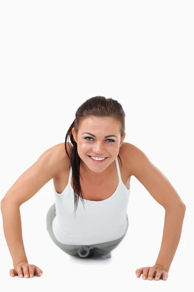 Uśmiechający się kobieta robi push up — Zdjęcie stockowe