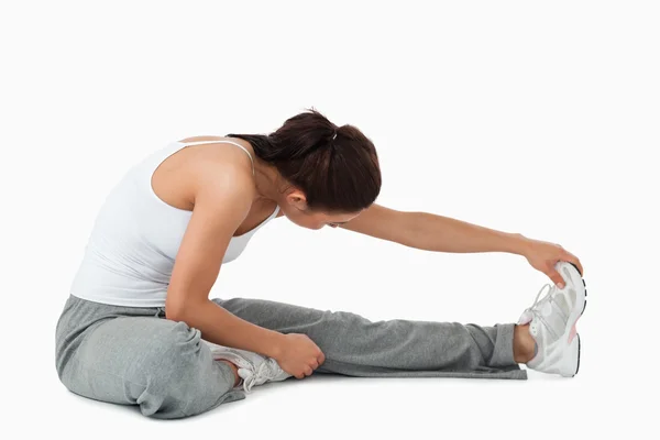 Vista laterale della donna che fa stretches — Foto Stock