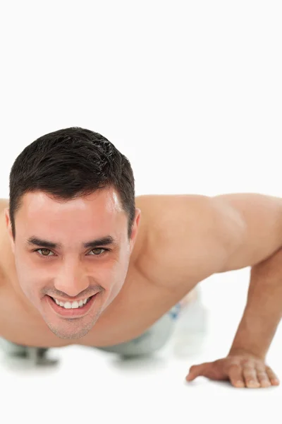 Usmívající se mladý muž dělá push up — Stock fotografie