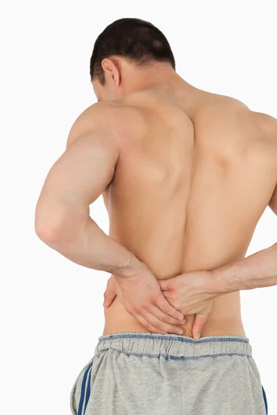 Молодой мужчина страдает от болей в спине — стоковое фото