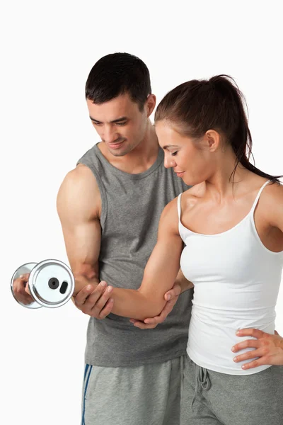 Portrait of a man helping a woman to work out — Stock Photo, Image