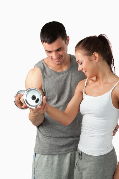 Portrait of a handsome man helping a woman to work out — Stock Photo, Image