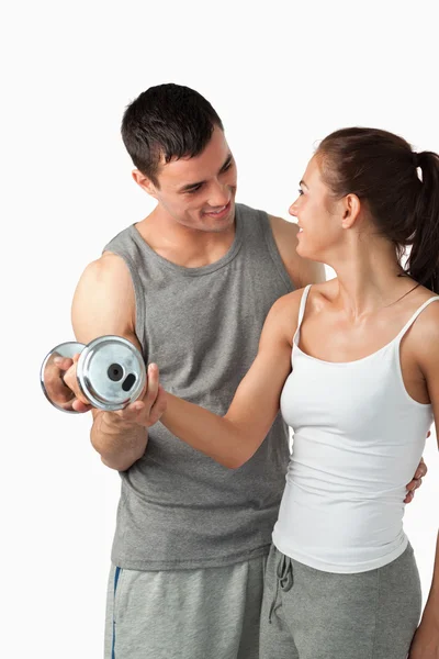 Portrait of a man helping a young woman to work out — Stock Photo, Image