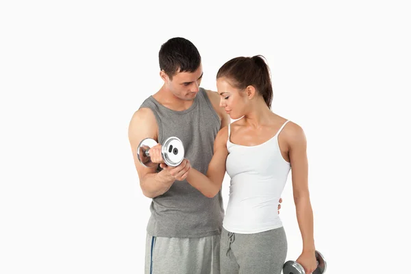 Man helping a young woman to work out — Stock Photo, Image