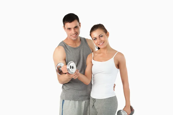 Man helping a gorgeous woman to work out — Stock Photo, Image