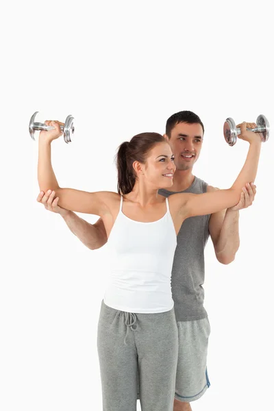 Portrait of a young man helping a gorgeous woman to work out — Stock Photo, Image