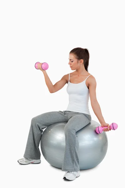 Retrato de una linda mujer haciendo ejercicio con pesas y una pelota —  Fotos de Stock