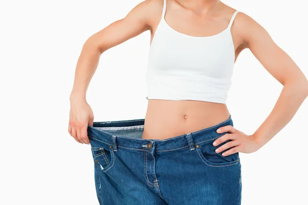 Thin woman wearing too large jeans — Stock Photo, Image
