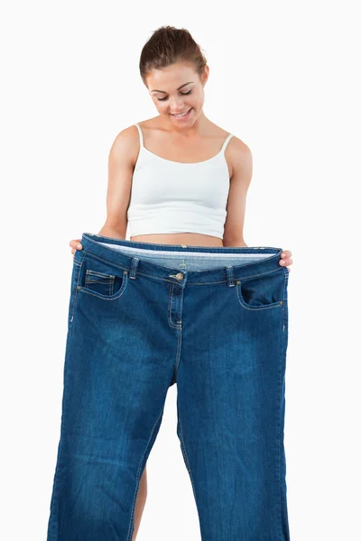 Porträtt av en vältränad kvinna visar stora jeans — Stockfoto