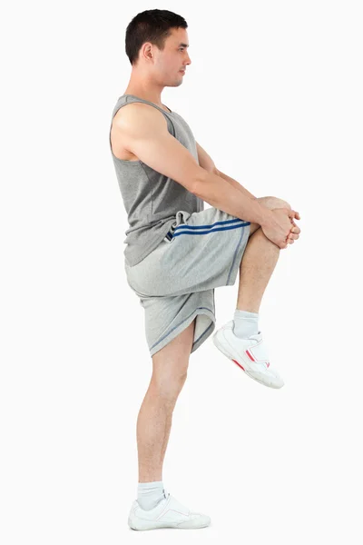 Portret van een jonge man die zich uitstrekt zijn been — Stockfoto