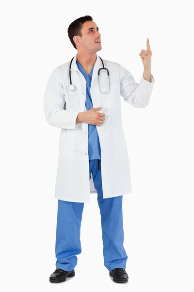 Porträt eines jungen Arztes, der auf einen Kopierraum zeigt — Stockfoto
